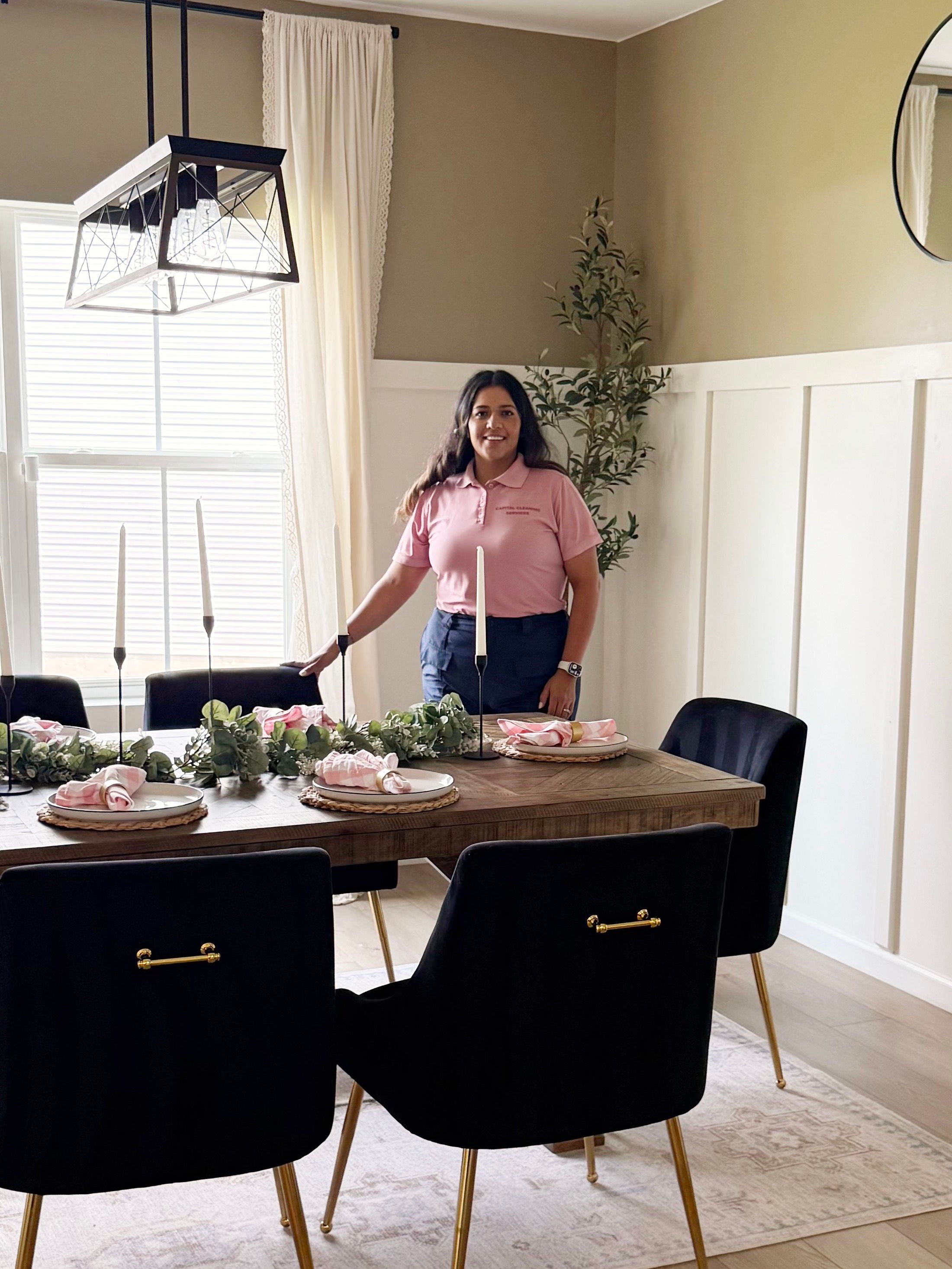 Capital Cleaning owner beside a set dining table after cleaning