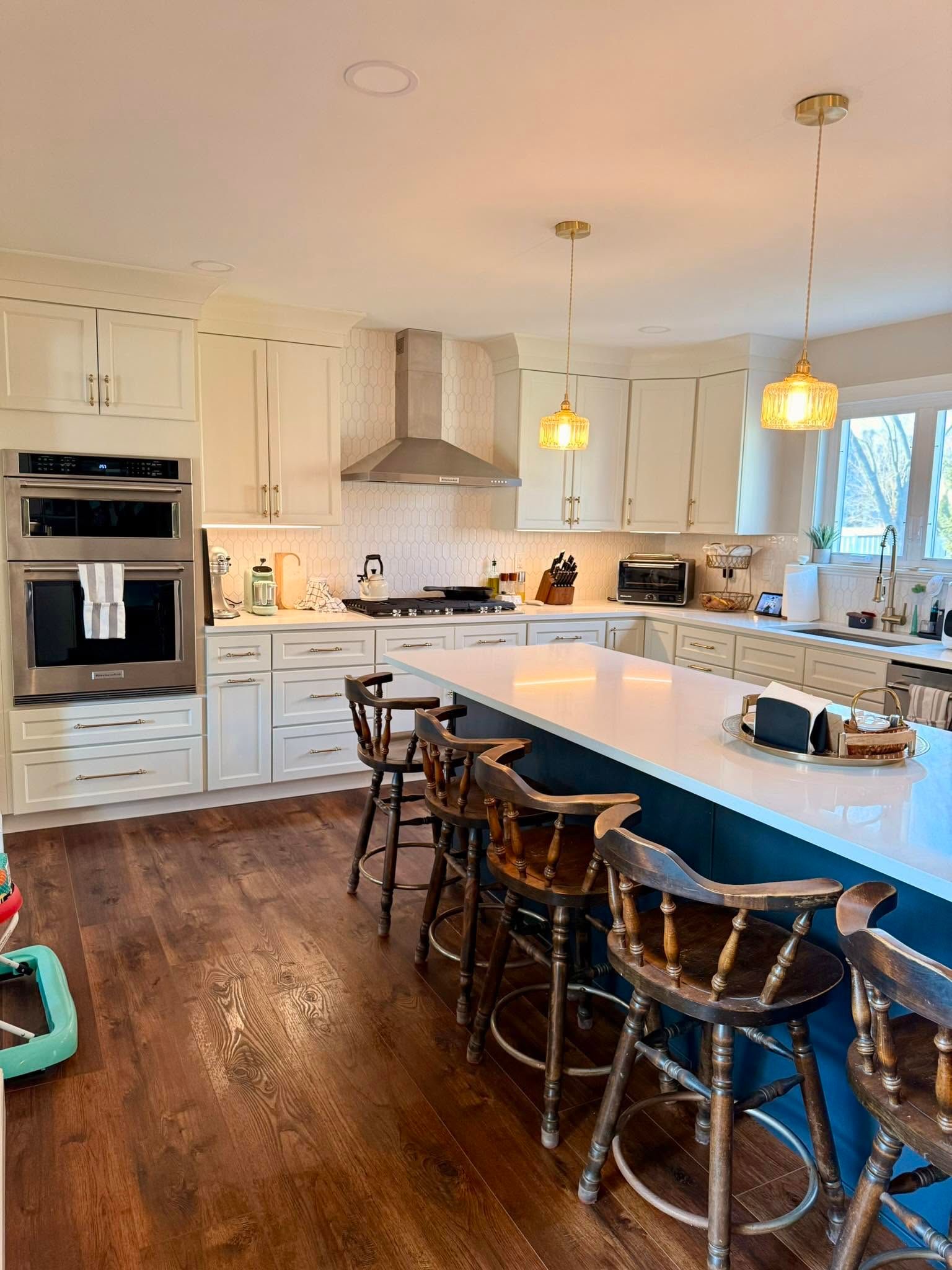 A bright, freshly cleaned kitchen with a large island and pendant lighting